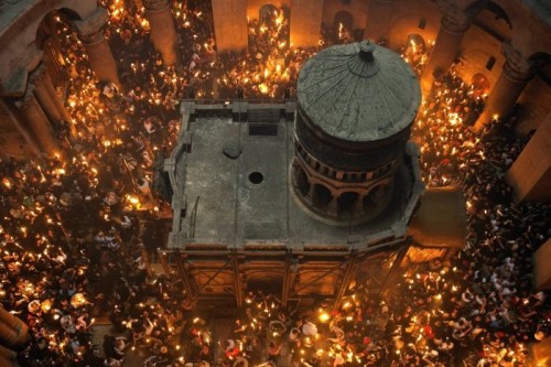 Vista de la edícula en el interior de la Basílica, rodeada por fieles con velas con ocasión de la Noche de Pascua. Basílica del Santo Sepulcro, Jerusalén (Israel).