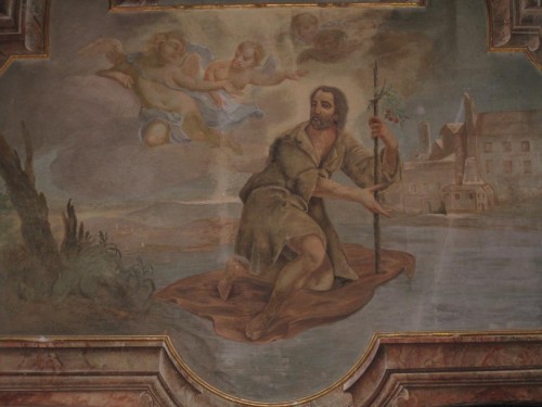 San Gerardo cruza el río sobre su manto.