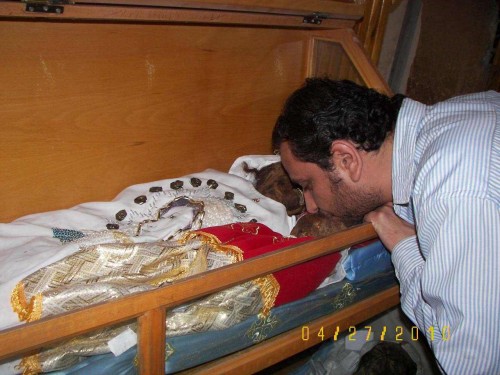 Un fiel besa las reliquias de un bebé, colocado junto a su madre. Monasterio de los Mártires, Akhmim (Egipto).