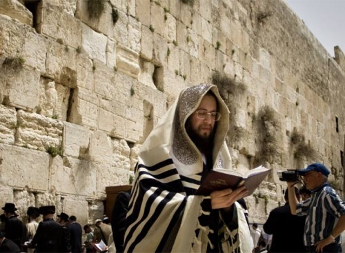 Fotografía de un rabino, orando con el Muro de las Lamentaciones a su espalda. Jerusalén (Israel).