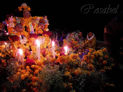 Familiares velando en la tumba de sus difuntos con el tradicional retablo adornado con flores y dulces en el cementerio de la isla de Janitzio. Fotografía: Rosabel Bustamante.