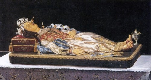 Imagen yacente de la Beata que contiene sus reliquias (los husos clavados en la cabeza, cuello y pecho indican las heridas mortales). Ghemme, Italia.