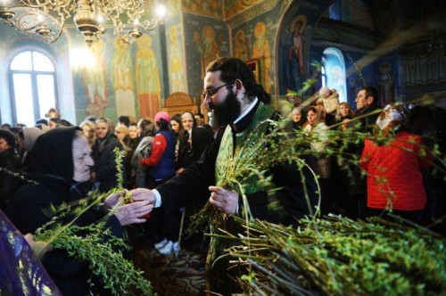 Domingo de Ramos: el sacerdote rumano reparte ramas de sauce entre los cristianos de la iglesia.
