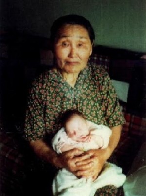 Fotografía de Santa Olga Michael con uno de los bebés que ayudaba a traer al mundo.