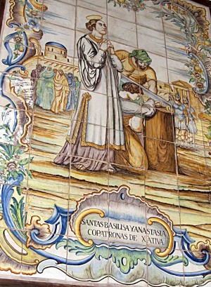 Las Santas sufriendo la amputación de las manos. Cerámica devocional en la calle de las Santas, Xàtiva, Valencia (España).