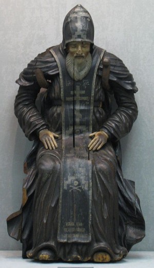 Escultura del santo sentado y en oración.